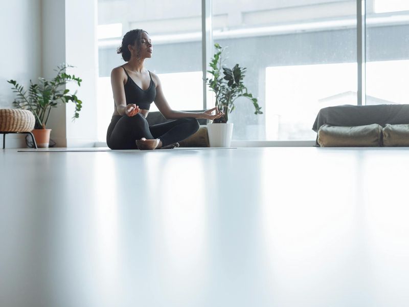A person in a focused yoga pose, seen from a low angle.