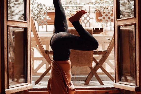 Person practicing a calm yoga pose in a bright, minimalist room.